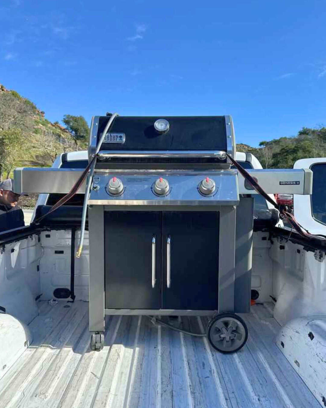 Large outdoor grill loaded in a delivery truck, ready for a summer cookout.