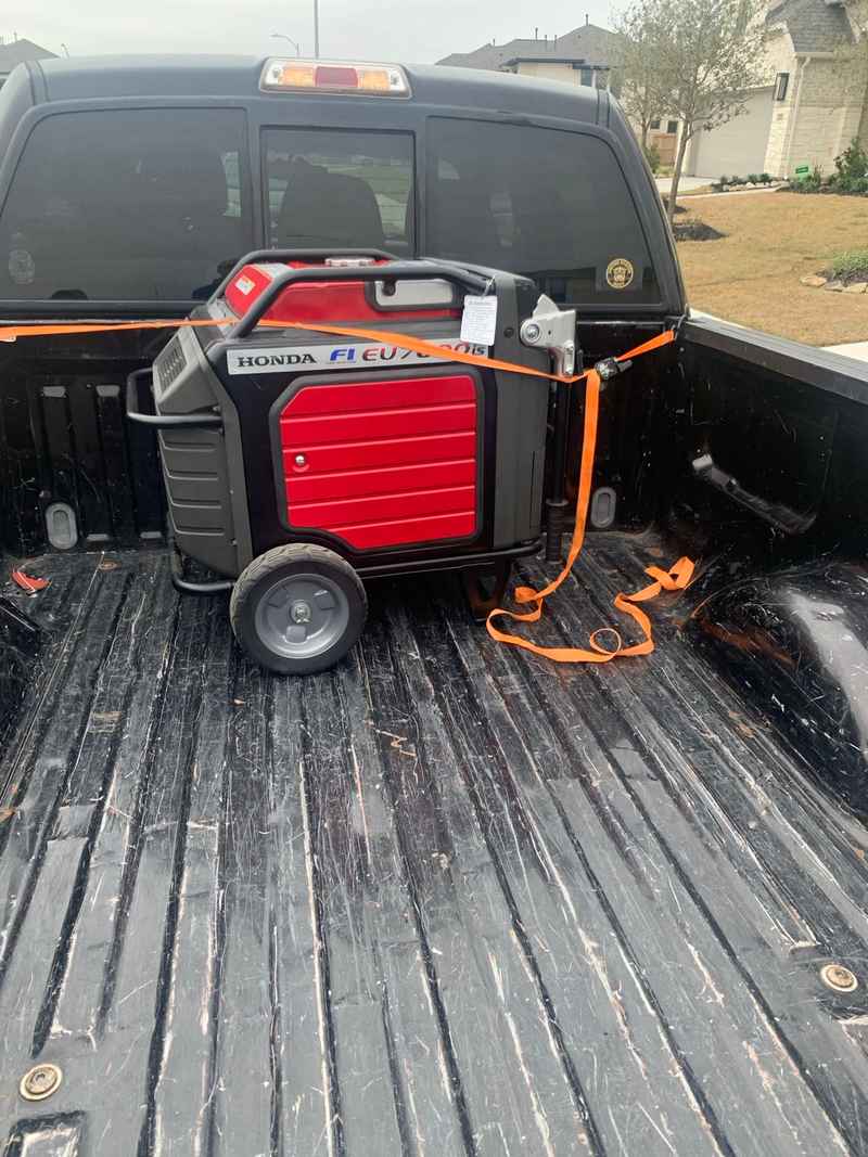 Portable Honda generator secured in the back of a pickup truck for hurricane prep.