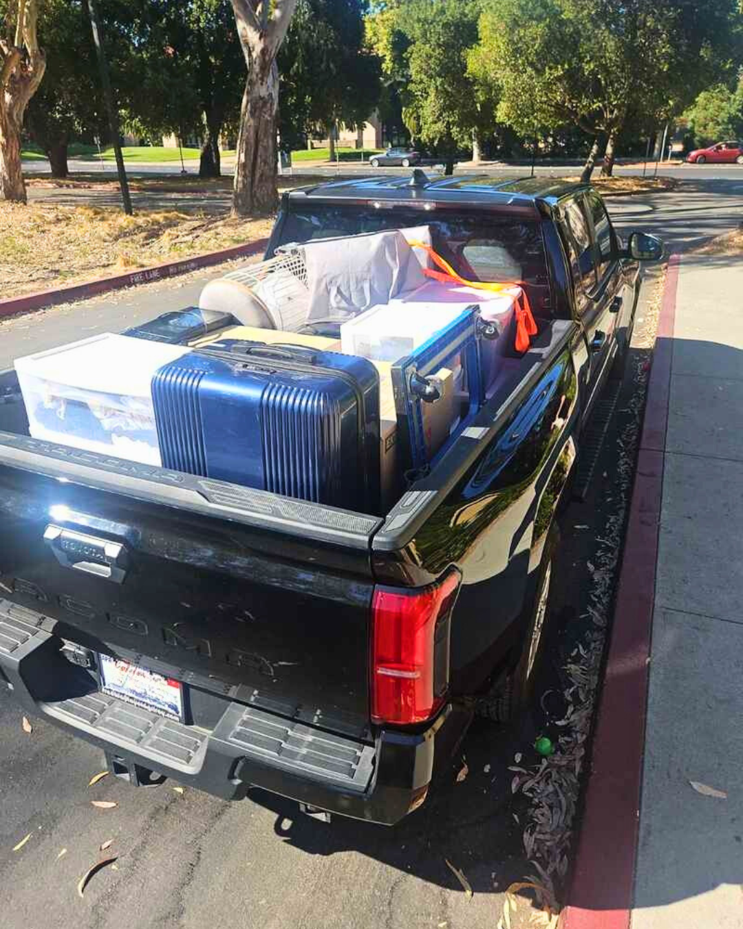 Pickup truck loaded with suitcases, dorm supplies, and essentials for college move-in.