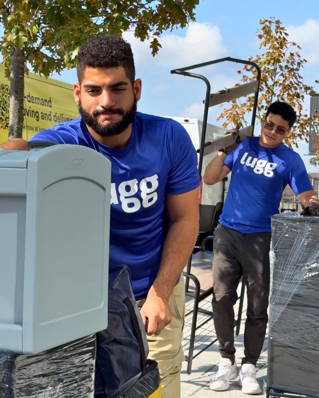 Lugg movers carrying storage bins and furniture for a college dorm setup.