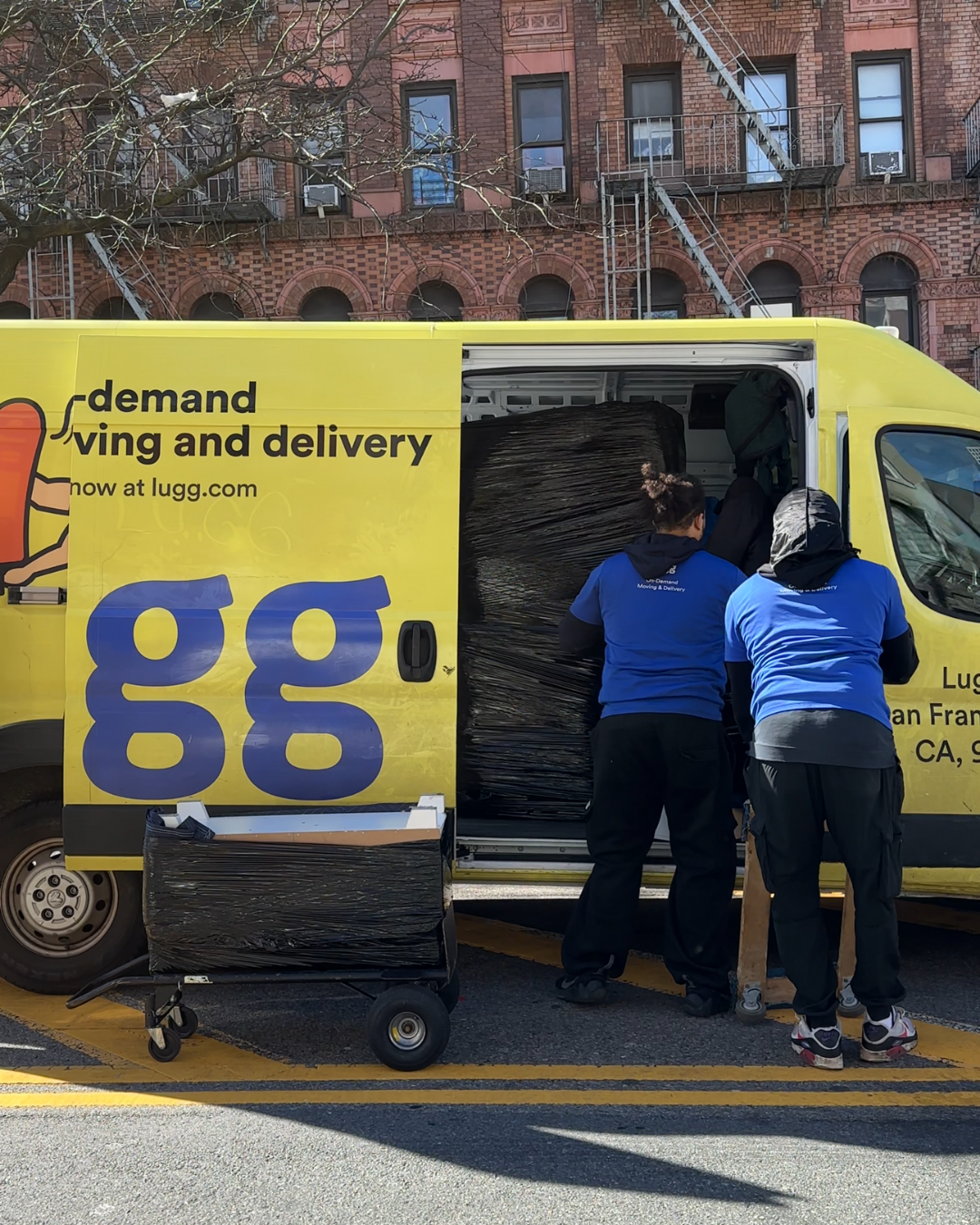 Three Lugg movers loading a tightly packed yellow Lugg van during a same-day move in NYC.