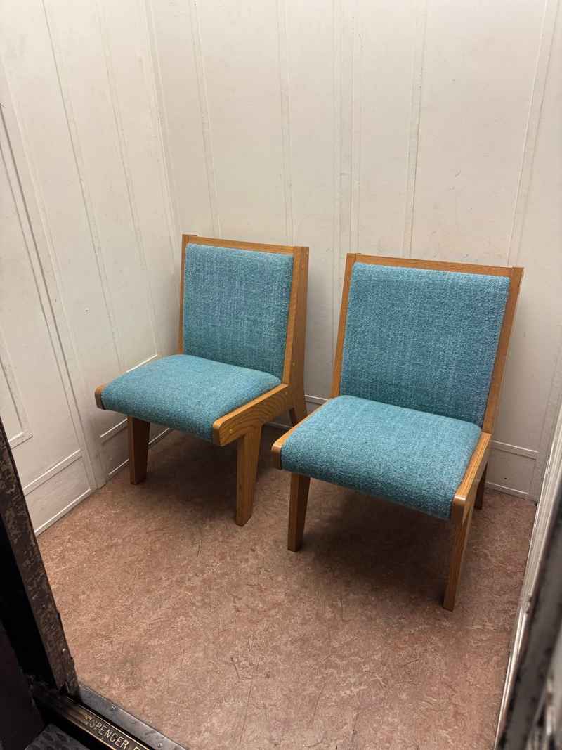 Two light-blue upholstered chairs placed near a wall, prepared for local furniture pickup through a delivery service.