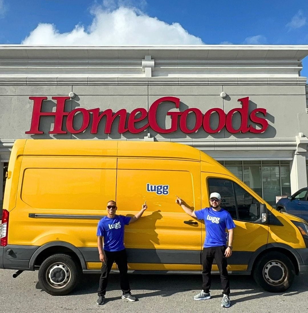 Lugg drivers standing with an XL cargo van outside a retail store for a furniture delivery job.