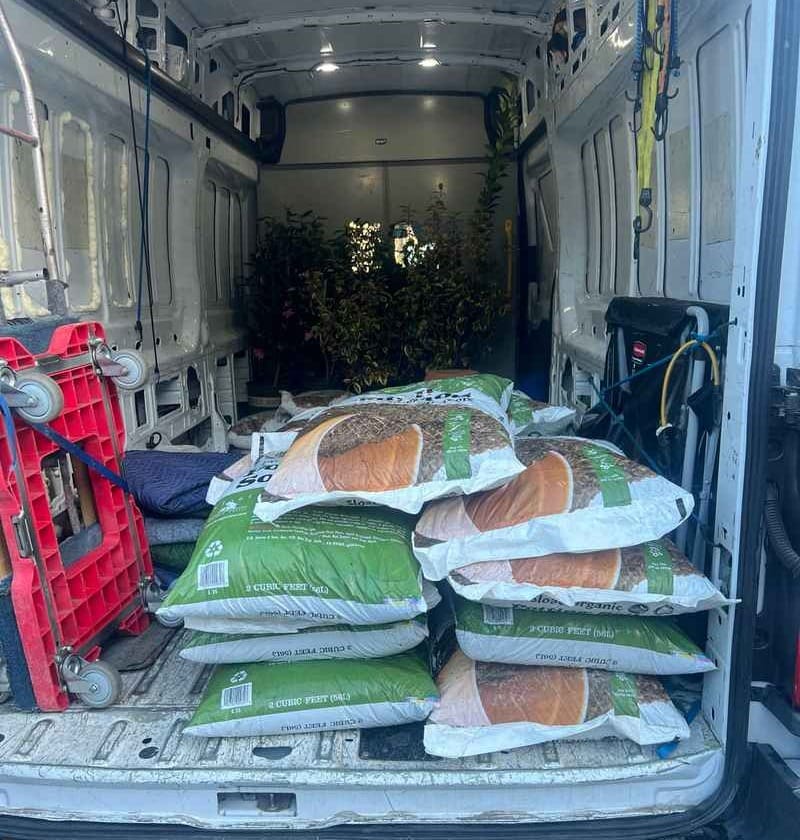 A Lugg XL Sprinter Van carrying large shrubs and bags of soil for Sloat Garden Center delivery.
