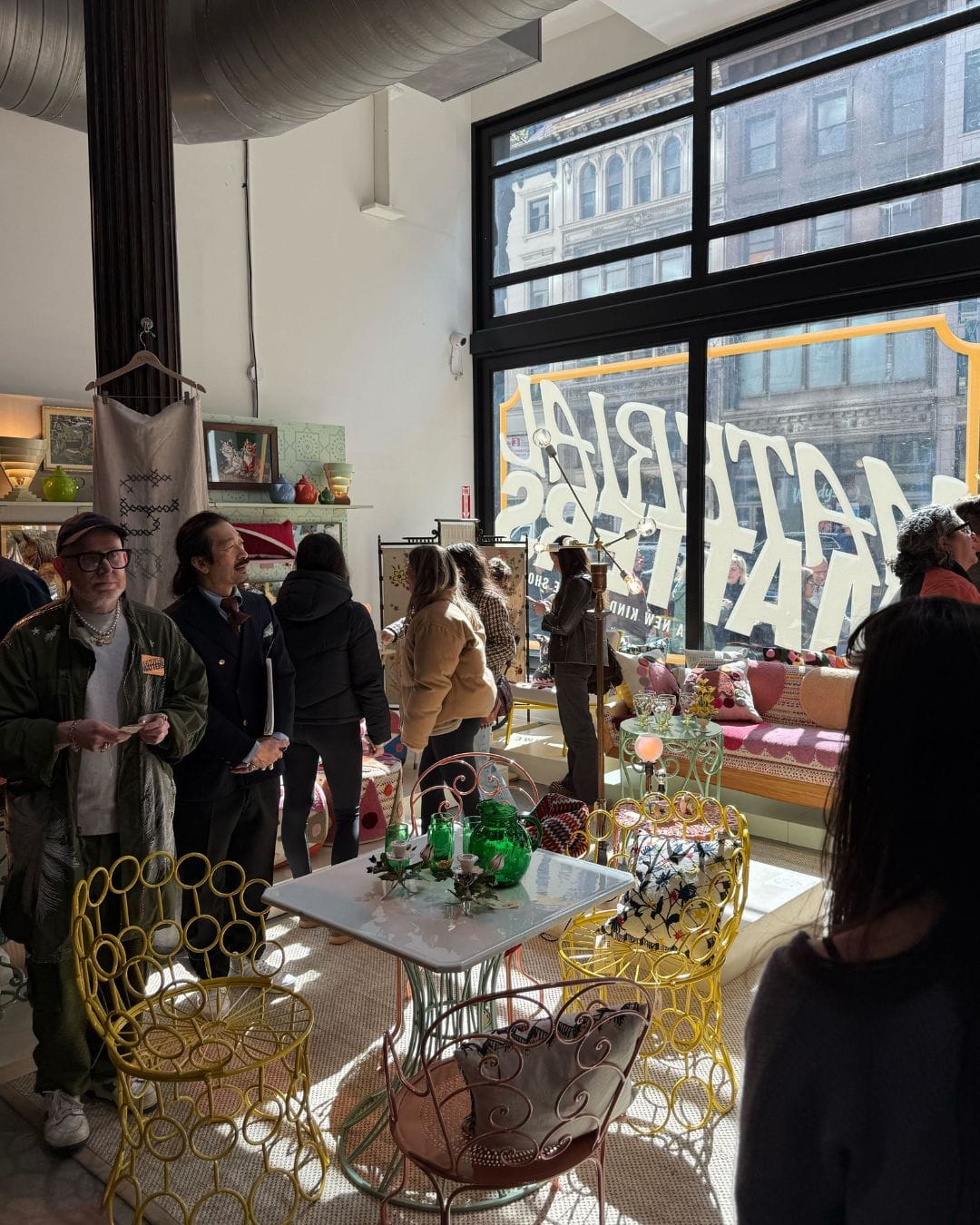 Shoppers browsing vintage furniture and design objects near the window at Material Matters NYC