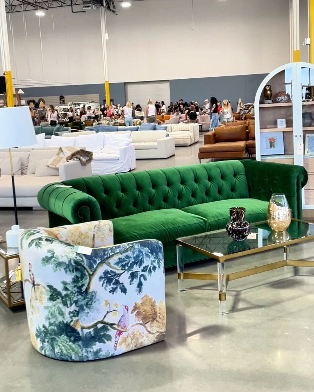 Green tufted velvet Chesterfield sofa and botanical print swivel chair on the Anthropologie Home Outlet showroom floor