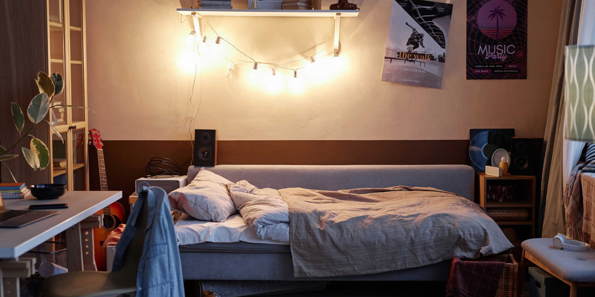 A decorated college dorm room with string lights above the bed, posters, and personal touches.