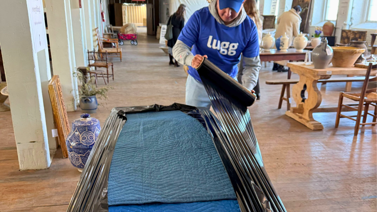 Lugg mover wrapping antique furniture with moving blankets at Sylvie Estate Sale in Newburgh NY